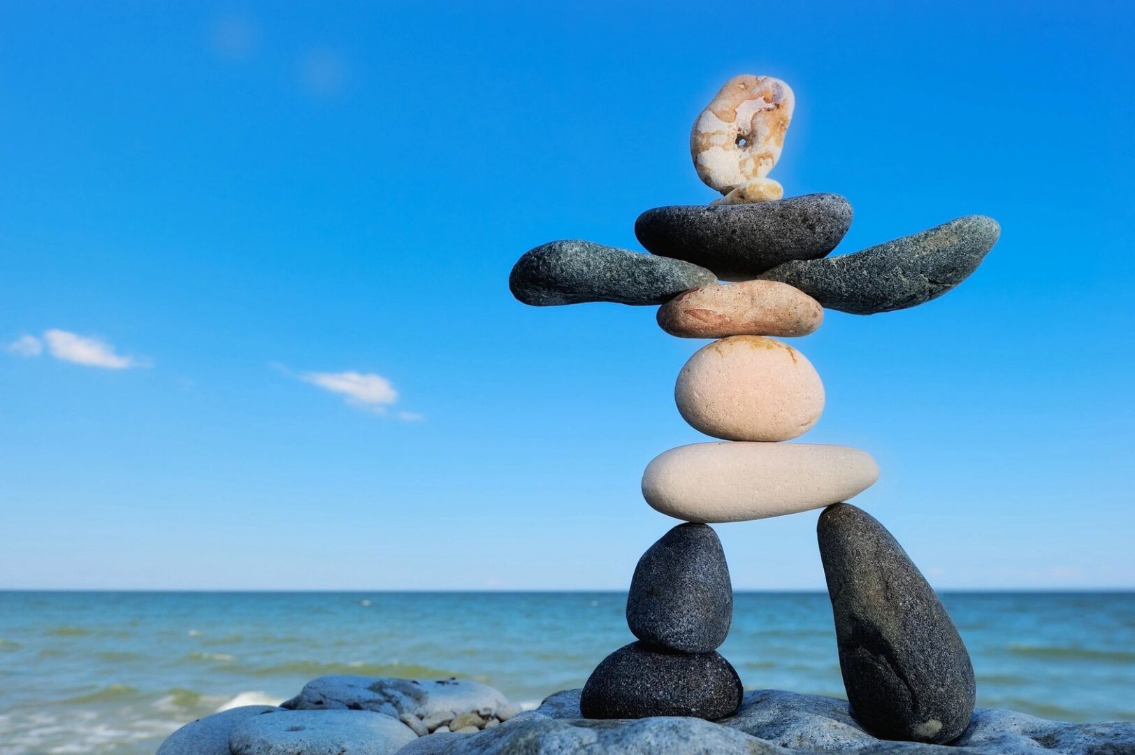 A rock sculpture of a person balancing on top of rocks.