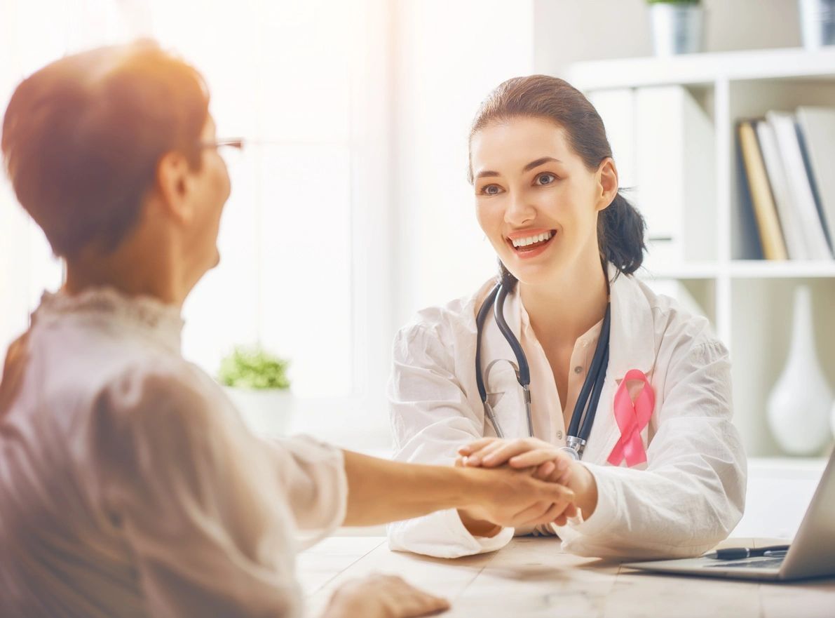 A woman in white coat holding hands with another person.