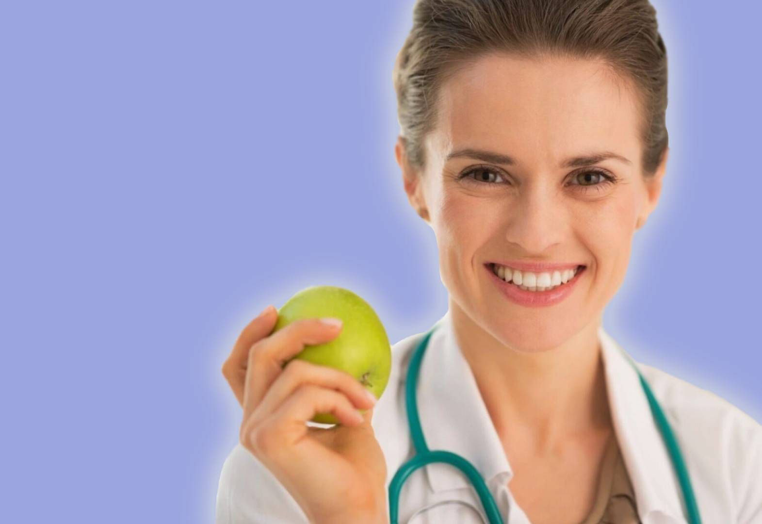 A woman holding an apple and smiling for the camera.