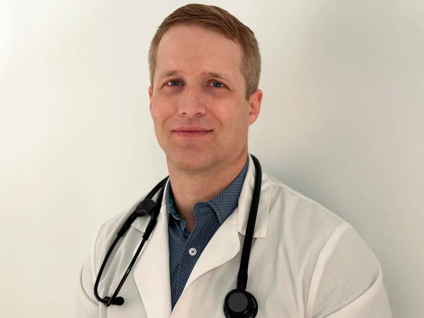 A man in white lab coat with stethoscope.